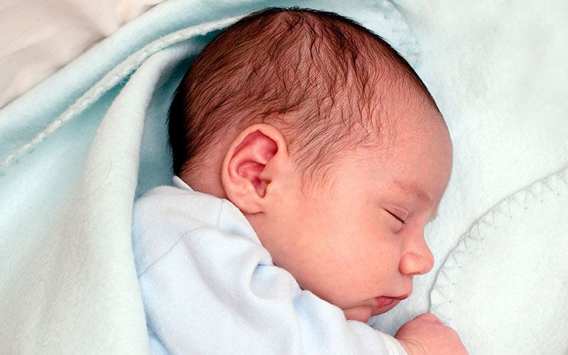 Një i porsalindur në gjumë, i mbështjellë me një batanije